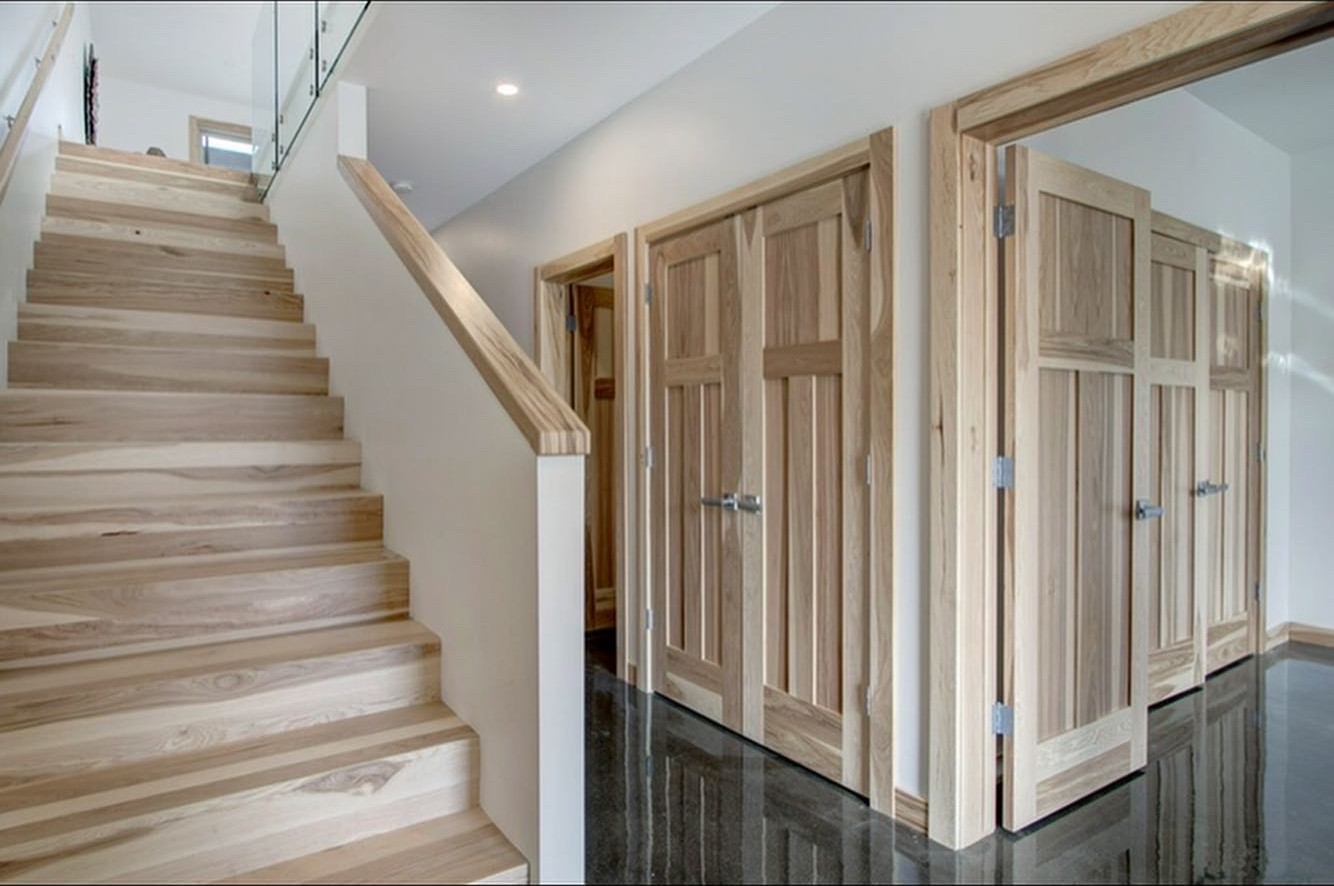 A light timber staircase and matching timber doors above a glossy floor
