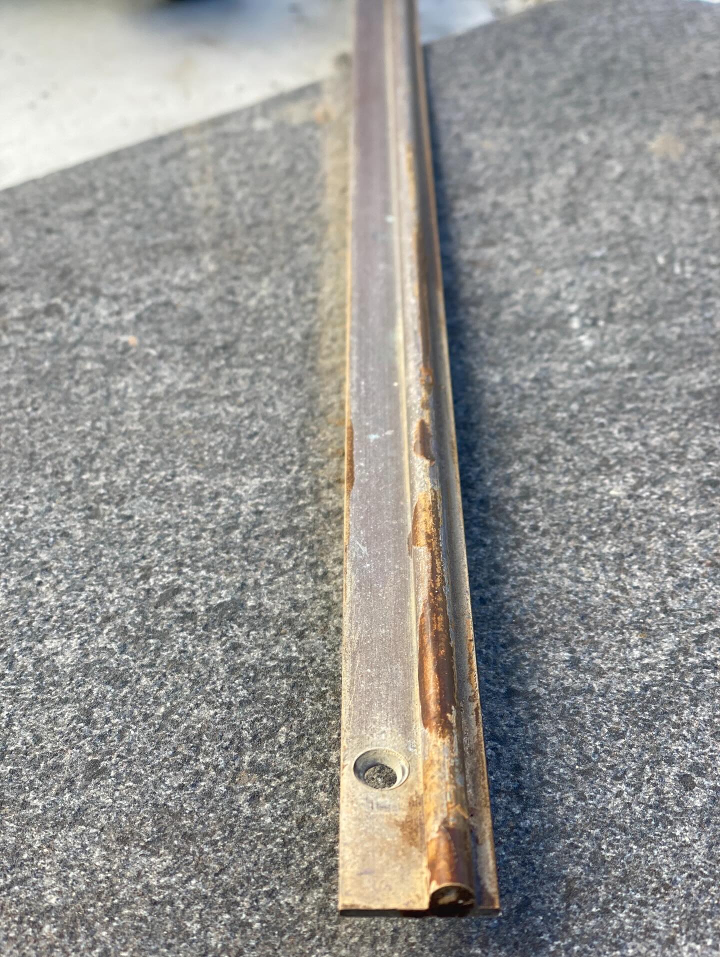 A restored brass door track set into a stone floor
