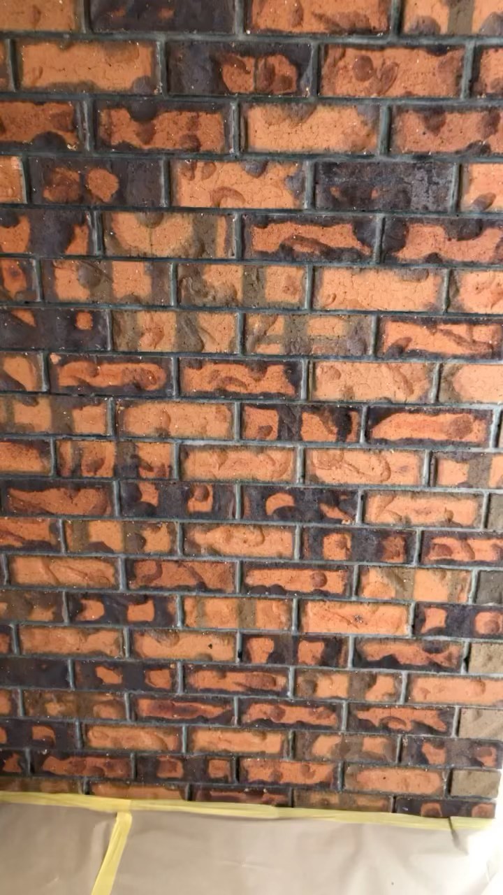 Red brick wall mid-coat with the base protected by drop sheets