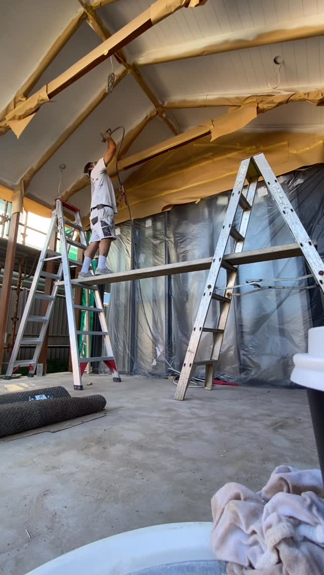 A new-build raked ceiling being painted from trestles